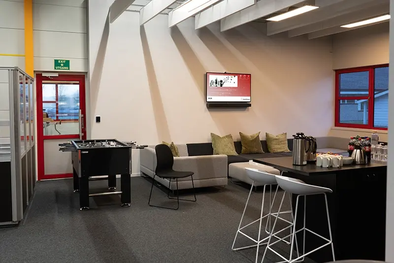 Pleasant sitting area in the demonstration hall, with a digital notice board showing the latest news from AutoStore.