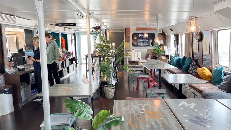 Photo from Maritiman's maritime entrance and café. An information screen on the wall is integrated in a way that emphasizes the rustic style.