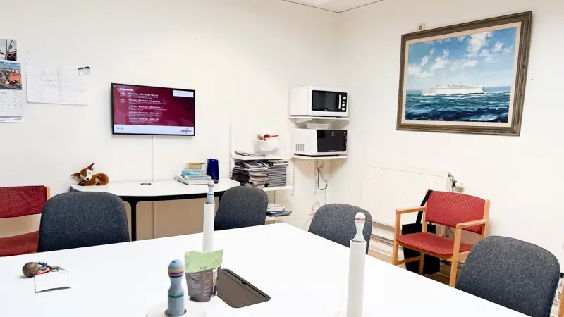 Photo from Maritiman's staff room, where an information screen is mounted on the wall.