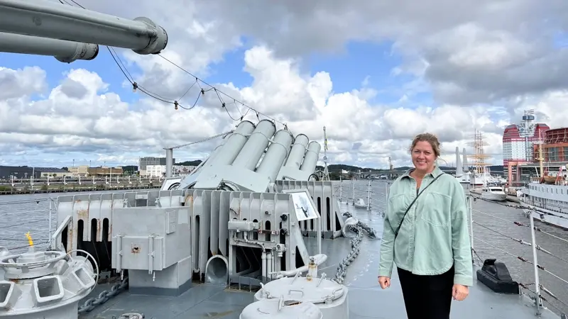 Emelie Leetma, Marketing Manager at Maritiman, standing on the deck of HMS Småland. Photo.
